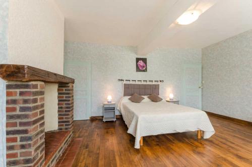 a bedroom with a bed and a brick fireplace at Les cas rouge 