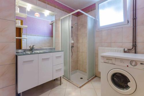 a bathroom with a washing machine and a shower at Les cas rouge 