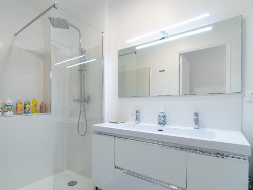 a white bathroom with a sink and a mirror at LE CELESTE - HYPERCENTRE PARKING ET NETFLIX GRATUITS PROCHE TRAMWAY ET PARC DE LA TETE D'OR in Villeurbanne