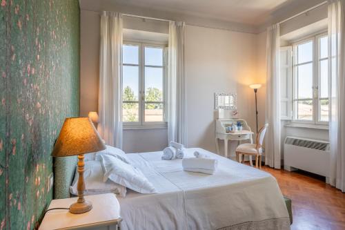 een slaapkamer met een bed en een tafel met een lamp bij Villa Agnese Suites in Lucca