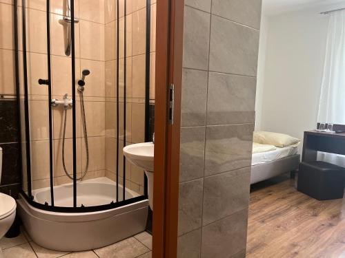 a bathroom with a shower and a toilet and a sink at Motel w Łące in Bolesławiec