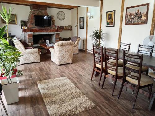 - un salon avec une table, des chaises et une cheminée dans l'établissement Etno Dušnik, 