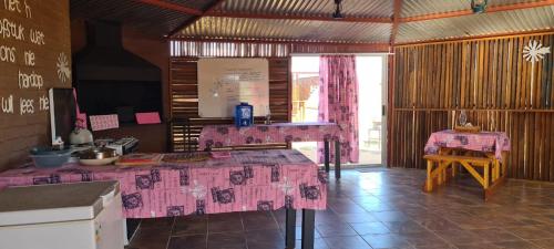 una cocina con mesas rosas en una habitación en Kallabaskop Eco lodge, en Soebatsfontein