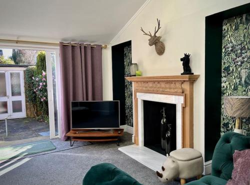 a living room with a television and a fireplace at The Lytham Cottage in Lytham St Annes