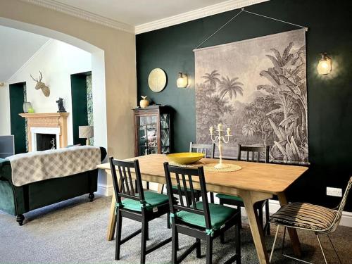 uma sala de jantar com uma mesa de madeira e cadeiras em The Lytham Cottage em Lytham St Annes