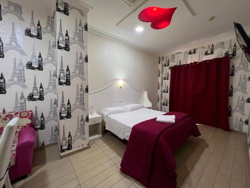 a bedroom with a bed and a red heart on the wall at Hotel Tiffany in Varcaturo