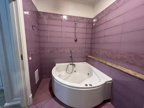 a pink bathroom with a bath tub in it at Hotel Tiffany in Varcaturo