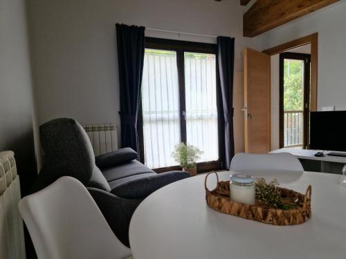 a living room with a white table and chairs at Apartamentos Villa de Panes - San Roque in Panes