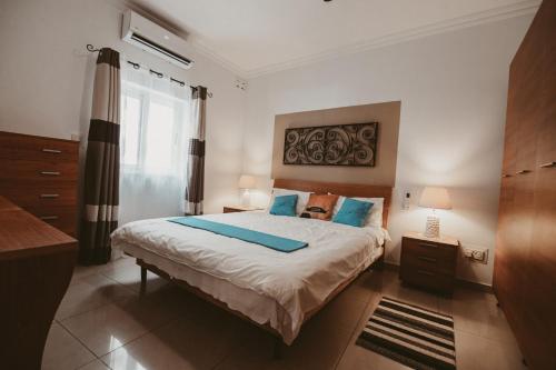 a bedroom with a large bed with blue pillows at Lovely, central 2BR home, just off St Julians w/AC by 360 Estates in Is-Swieqi