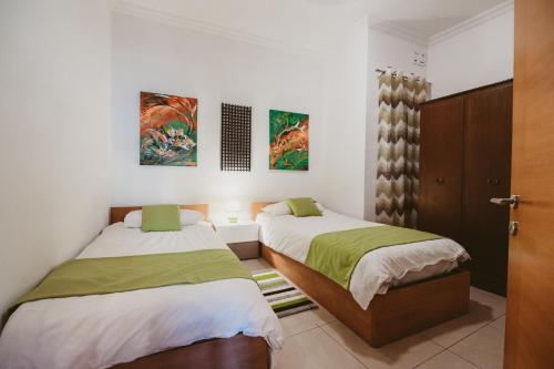 two beds in a room with white walls at Lovely, central 2BR home, just off St Julians w/AC by 360 Estates in Is-Swieqi