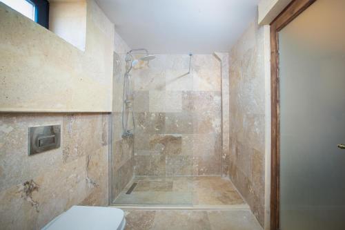 a bathroom with a shower with a toilet at Cappadocia Pyramid Stone House in Uchisar