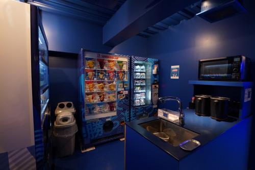a blue kitchen with a refrigerator and a sink at esports hotel e-ZONe 電脳空間 in Osaka