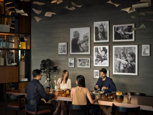 a group of people sitting at a table in a restaurant at The WB Abu Dhabi, Curio Collection By Hilton in Abu Dhabi