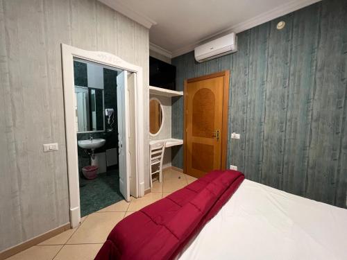 a bedroom with a bed and a bathroom with a sink at Hotel Tiffany in Varcaturo