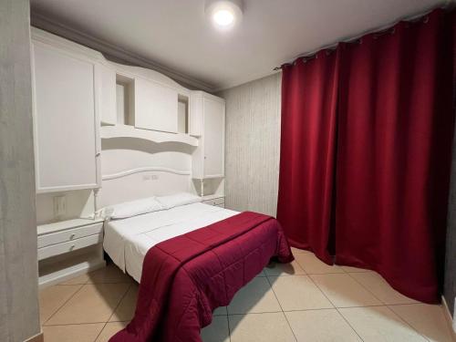 a bedroom with a bed with a red curtain at Hotel Tiffany in Varcaturo