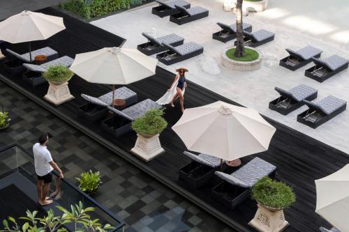 una vista aérea de un restaurante con mesas y sombrillas en The Trans Resort Bali en Seminyak