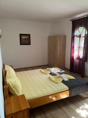 a bedroom with a large bed with yellow sheets and a window at Hotel Gamartata in Duni