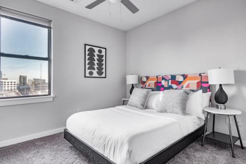 um quarto branco com uma cama grande e uma janela em CozySuites Music Row Charming 1BR free parking 49 em Nashville