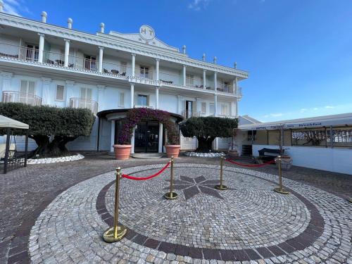 a large white building with a red rope around it at Hotel Tiffany in Varcaturo