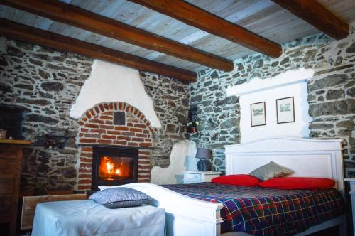 a bedroom with a bed and a brick fireplace at Chalet in pietra e legno con caminetto in Inverso Pinasca