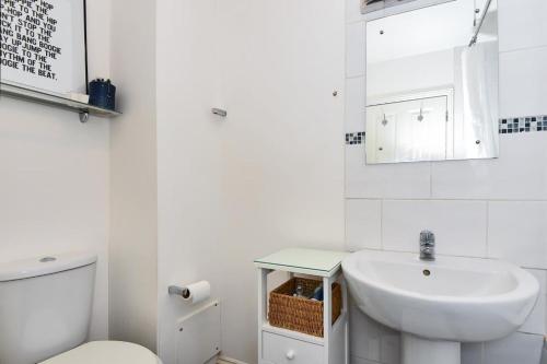 uma casa de banho branca com um lavatório e um WC em Reading Central Apartment em Reading