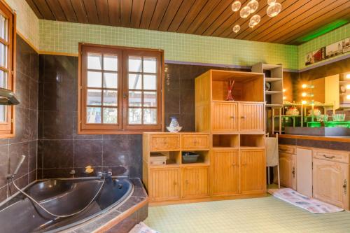 a large bathroom with a tub and a sink at Le tiki beach in Buchères