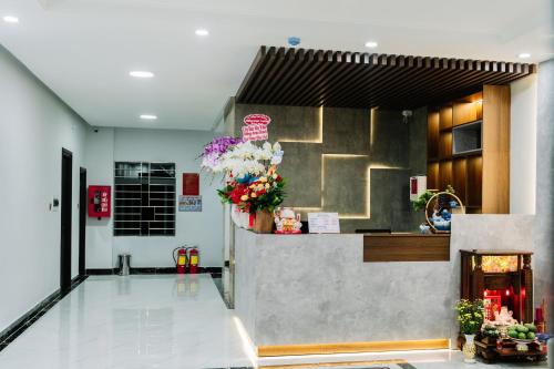a lobby with a counter with flowers on it at Anna Hotel Binh Duong in Bến Cát