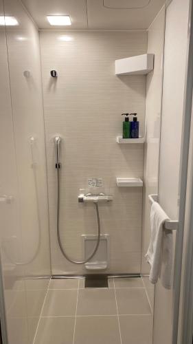 a bathroom with a shower with a glass door at Business Inn Fukuyama in Fukuyama