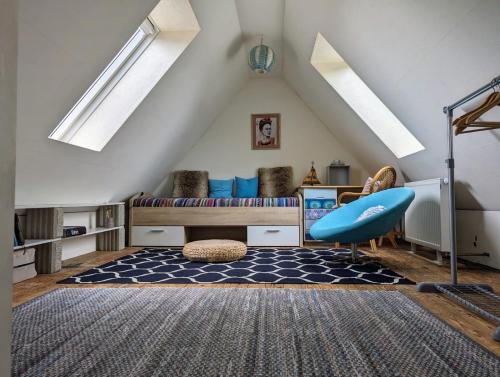 a attic room with a bed and a blue chair at Casa Azul in Flensburg