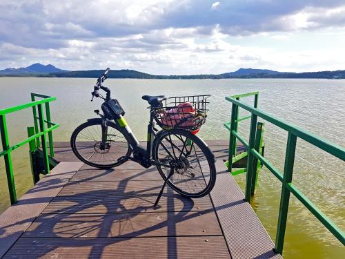 a bike parked on a dock next to the water at U Leknínu in Doksy