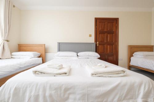 a bedroom with two beds with white towels on them at Four Seasons B&B in Galway