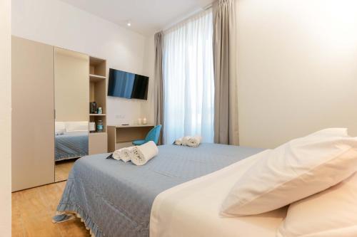 um quarto de hotel com uma cama e uma televisão em Aqua Comfort Rooms - Eja Sardinia em Cagliari