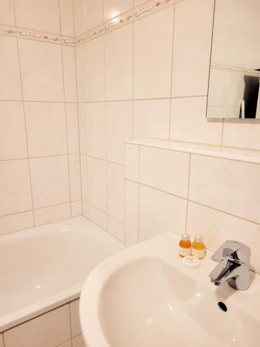 a white bathroom with a sink and a bath tub at Winterberg Appartement 21085 in Winterberg
