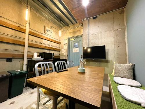 a dining room with a wooden table and chairs at 365BASE outdoor hostel in Hamamatsu