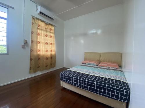 ein Schlafzimmer mit einem Bett in einem Zimmer mit einem Fenster in der Unterkunft Ayana Homestay in Labuan