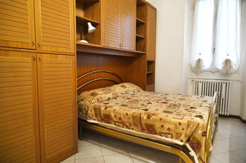 a bedroom with a bed and wooden cabinets at Casina modesta in Somma Lombardo