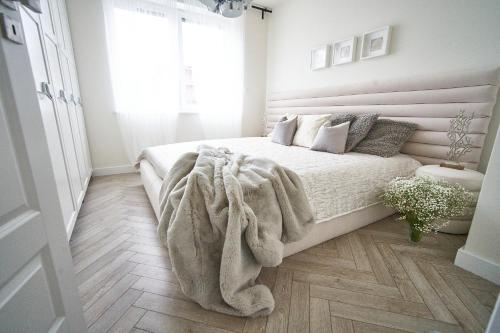 um quarto com uma cama com um cobertor no chão em SZAFIROWE APARTAMENTY 3 kryty basen i sauna RESORT KLIFOWA em Rewal