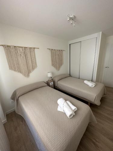 a room with two beds with towels on them at Apartamentos Encanto Mudéjar in Teruel
