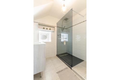 een badkamer met een douche en een glazen deur bij Au phil de lo in Dolancourt