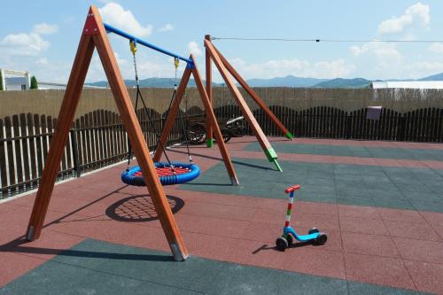a group of empty swings in a playground at Pensiunea La Luna in Negreşti-Oaş