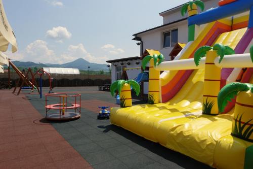 a playground with a slide and a play structure at Pensiunea La Luna in Negreşti-Oaş