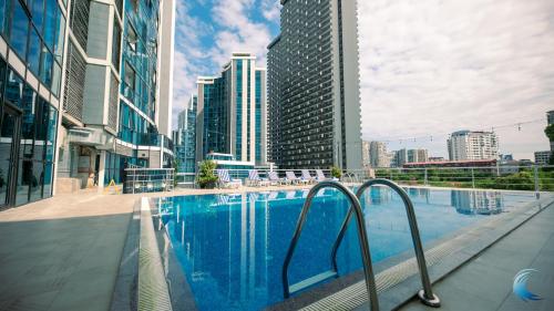 una piscina en una ciudad con edificios altos en New Wave Hotel, en Batumi