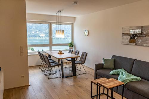 a living room with a couch and a table at Top 9 Alpe Maritima - Lakeview Apartment mit Bergkulisse in Annenheim