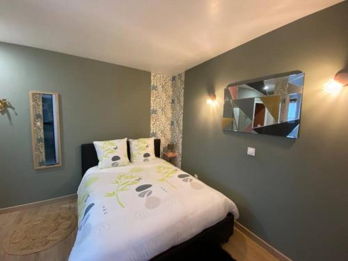 a bedroom with a large bed with a mirror at La belle vue in Accolay