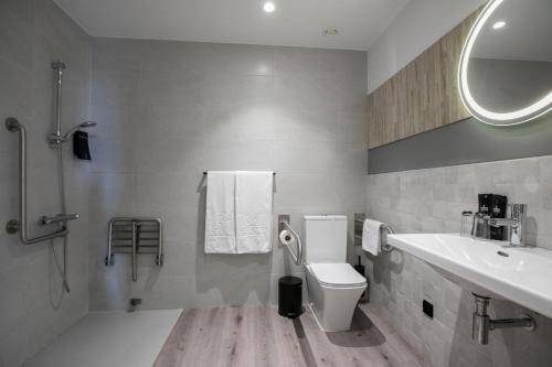 uma casa de banho com um WC, um lavatório e um espelho. em EVENIA CORAL BOUTIQUE em L'Estartit
