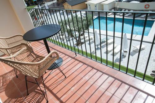 balcón con mesa, sillas y piscina en EVENIA CORAL BOUTIQUE en L'Estartit