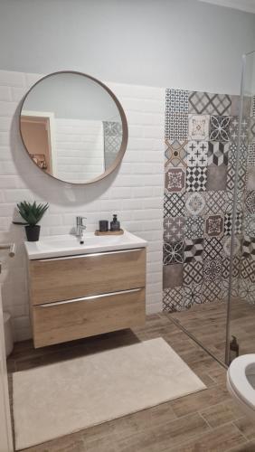 bagno con lavandino e specchio di Blue Apartament Timisoara a Uisenteş