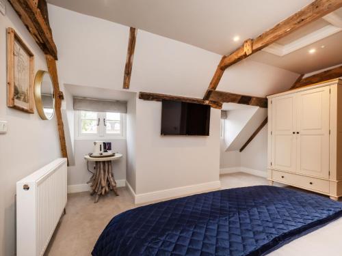 ein Schlafzimmer mit einem blauen Bett im Dachgeschoss in der Unterkunft The Stag, Oak Room in Salhouse