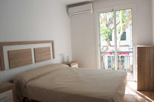 een slaapkamer met een bed en een groot raam bij Vacation rental Fuengirola in Fuengirola