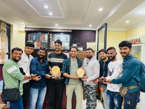 a group of men posing for a picture with two awards at HOTEL TRILOK in Kathmandu